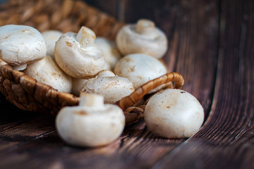 champignonsFresh mushrooms in a basket on a wooden background.