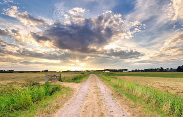 Fototapeta na wymiar sunrise over countryside road in Dutch farmland