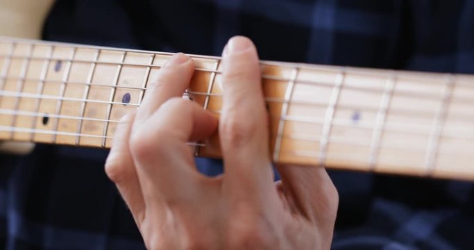 Guitar player practicing electric guitar, close-up at fretboard