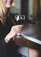 Lady Holding a Glass of Red Wine at a Bar