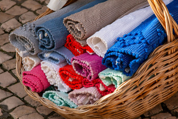 colorful mats lie in a wicker basket