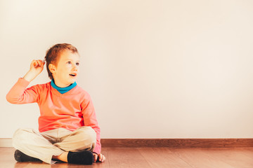 Independent child of 5 years combing himself sitting on the floor of his house