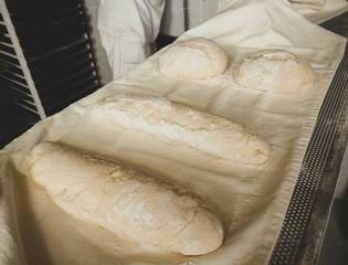 Production of baked bread with a wood oven in a bakery.