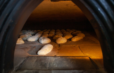 Production of baked bread with a wood oven in a bakery.