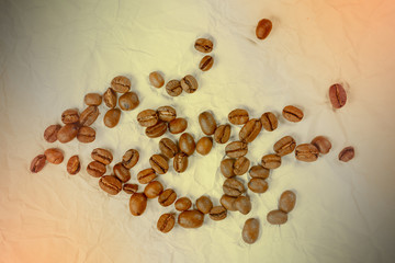 Coffee beans on vintage crumpled paper background. Some roasted coffee beans.