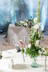 Floral decoration for wedding ceremony romance dining. Wedding banquet , festive decor. Bouquet from spring and summer flowers. Table layout. Restaurant interior. Concept of service and catering.