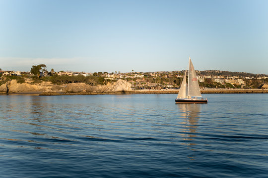 Sailboat Entering the Harbor at Sunset