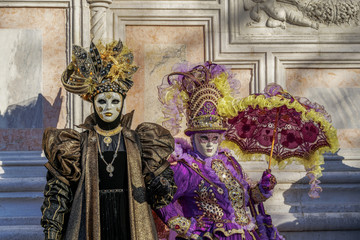 Fototapeta na wymiar Venice, Italy Carnival mask and costume poses in Campo San Zaccaria.Masked persons in traditional costume pose at a Venetian square during the Venice 2019 Carnival.