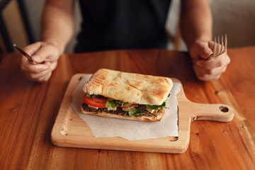Sandwich near crop man with cutlery 