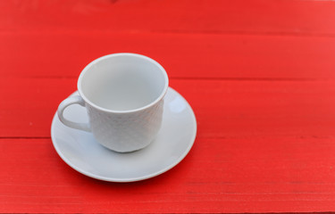 Empty white coffe cup on red wooden table. Copy space