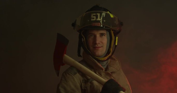 Fire fighter holding fireman axe looking stoic - slow zoom in