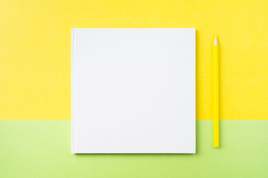 white square notebook on yellow and green paper