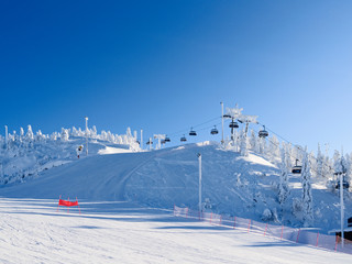 Kuusamo / Finland: Chairlift and slopes in the Ruka ski area on a beautiful and sunny day in February