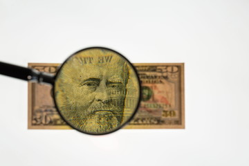 Close up view of magnifying glass over fifty dollar bill. Banknote. Beautiful backgrounds.