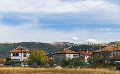 Typical natural rural landscape in Bulgaria, village with red roofs, hills on the horizon