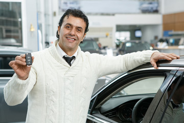 Fototapeta na wymiar Mature man choosing a new car at the dealership salon