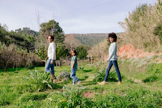 Happy family walking in the countryside, in a row