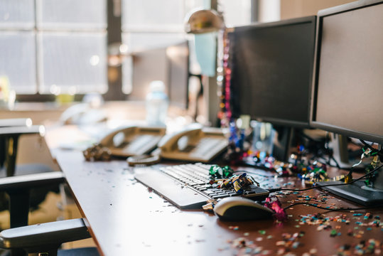 Desk with confetti and streamers on computer after a birthday party