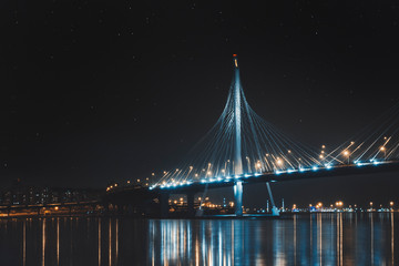 Beautiful cable-stayed bridge in St. Petersburg, Russia, with starry sky and cozy city lights