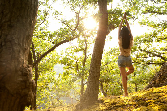 Young woman in forest practicing yoga