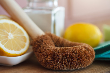 eco-friendly natural cleaning products, bamboo brush, lemon, baking soda (sodium bicarbonate) on wooden table, go green, zero waste lifestyle