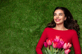 Young dreaming girl with flowers lying on meadow 