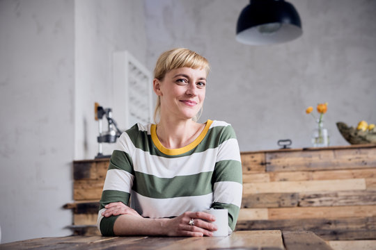 Portrairt of smiling woman with coffee mug at tablet