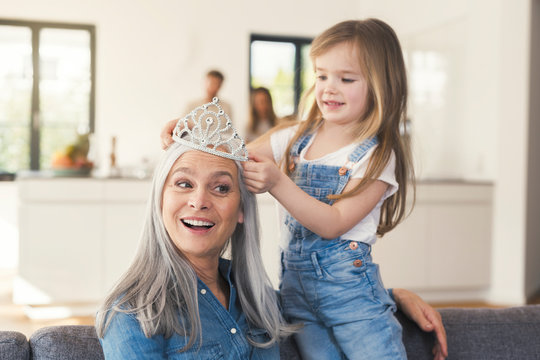 Granddaughter putting crown on grandmothes head