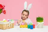 Lovely girl coloring eggs for Easter 