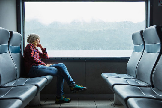 Chile, Hornopiren, woman sleeping at the window of a ferry