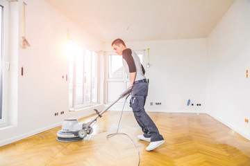 Versiegeln von Eichenparkett, Arbeiter mit spezialwerkzeug. Poliermaschine