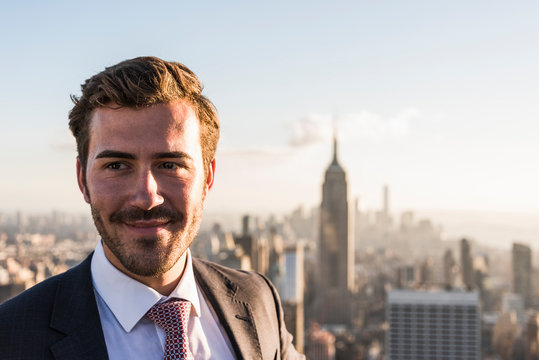 USA, New York City, smiling businessman on Rockefeller Center observation deck