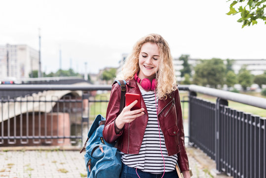 Portrait of smiling young woman looking at cell phone