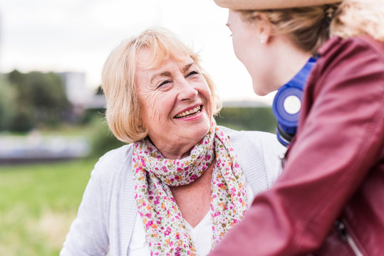 Portrait of happy grandmother talking to her granddaughter