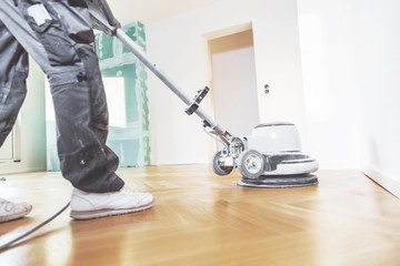 Fototapeta premium Varnishing of oak parquet floor, workers tool.