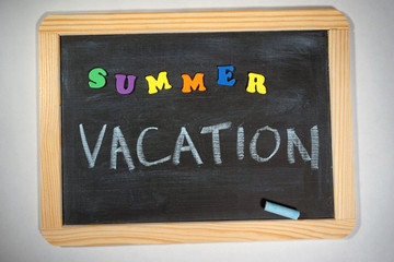 Fototapeta premium Summer vacation message on chalkboard