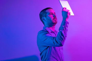 Businessman reading from a raised handheld tablet