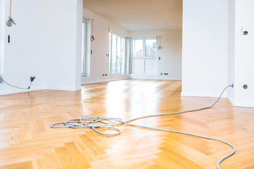 Leerer Raum mit frisch geölten Parkettboden und weißen Wänden