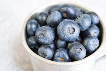 Blueberries in a rustic metal cup still life, selective focus