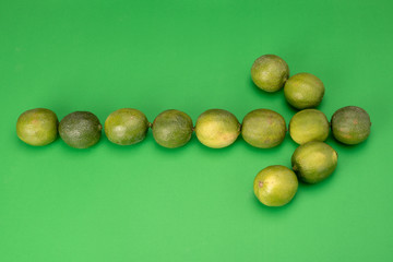 green arrow on green background made with limes ideal for health and fruits related signs or fruit and food business directions