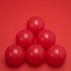 red balls isolated on red background arranged as a triangle with negative  space for text