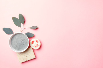 natural eco beauty products on pink background, luffa sponge, clay for making facial or body mask, handmade herbal and coconut soap and eucalyptus leaf, top view, copy space, flat layout - obrazy, fototapety, plakaty