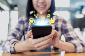 Close up smartphone social media network sharing and commenting in online community. Influencer woman's hand holding mobile phone and using applicaation social network service with like, love icon.