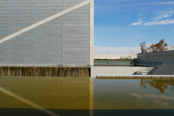 The modern structure is bordered by still water, creating a calm and balanced composition.