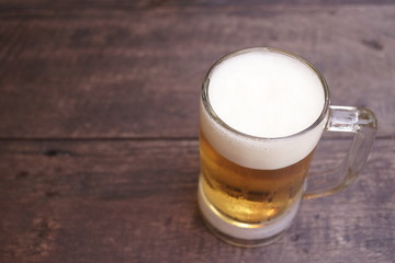 Glass of light beer on the wooden table