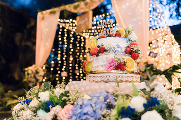 Wedding cake decorated with berry, strawberry, orange and you and me text