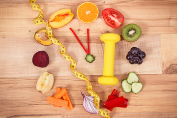 Fototapeta na wymiar Fresh fruits with vegetables, dumbbell and centimeter. Healthy sporty lifestyles concept