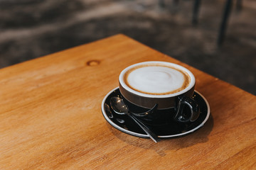 hot coffee in black cup on wooden table.