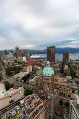 Obraz premium Aerial view of the modern city during a cloudy sunset. Taken in Downtown Vancouver, British Columbia, Canada.