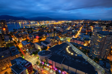 Fototapeta premium Downtown Vancouver, British Columbia, Canada - June 22, 2018: Aerial view of the modern city during night time after a cloudy sunset.